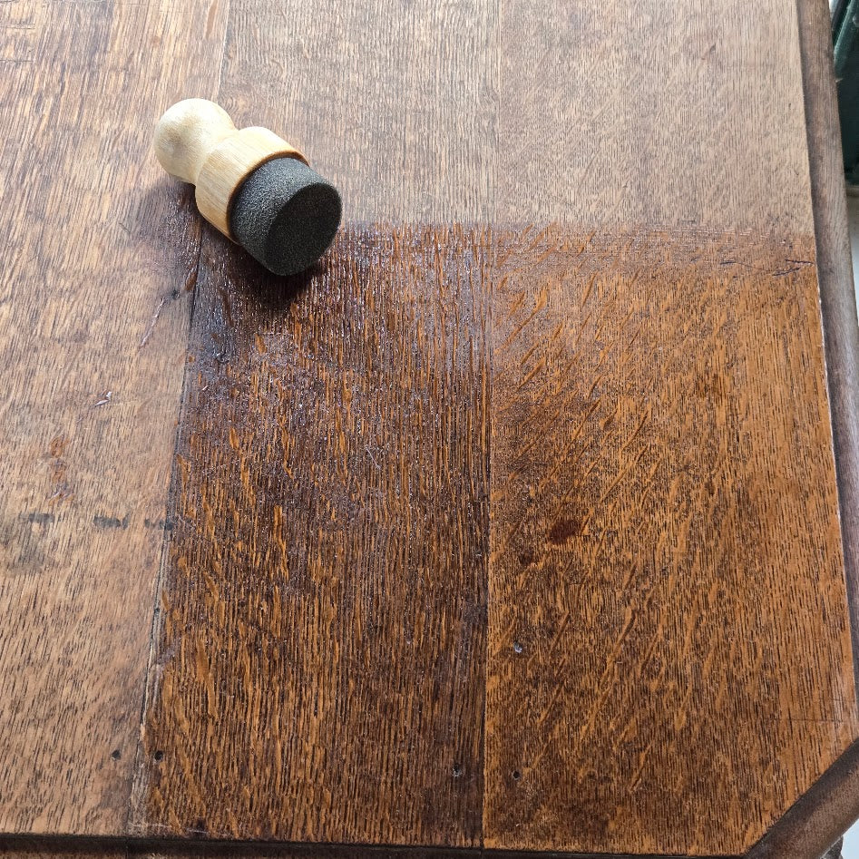 test du lait imperméabilisant sur une table en bois, avec piceau mousse applicateur posé dans le coin gauche.
