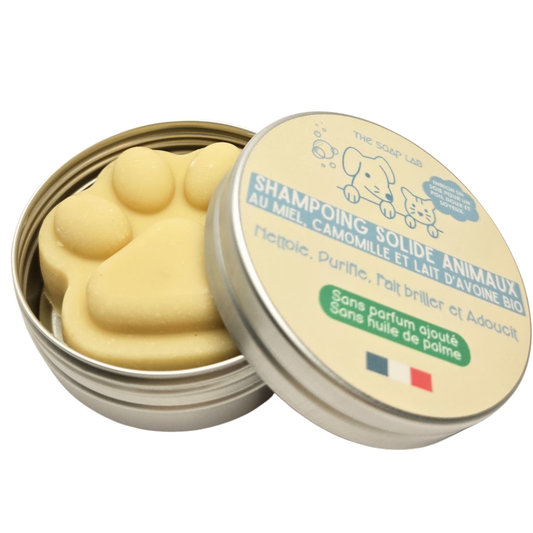 shampoing pour animaux en forme de patte de chien dans boîte en métal ronde de 35mL mi-ouverte et vue 3/4 supérieure sur fond blanc