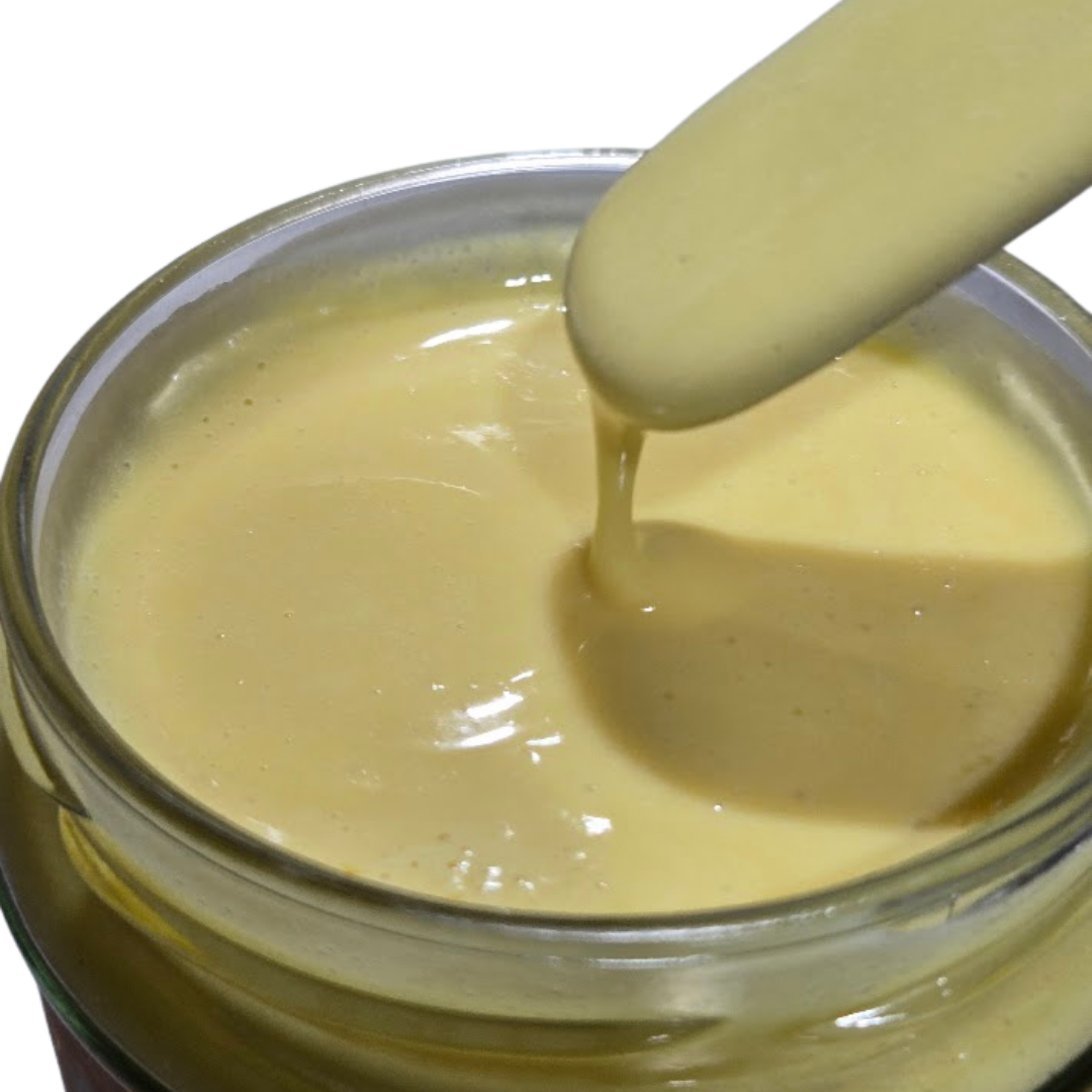 lait imperméabilisant bois dans bocal ouvert, avec spatule en métal qui fait couler le lait dans le bocal
